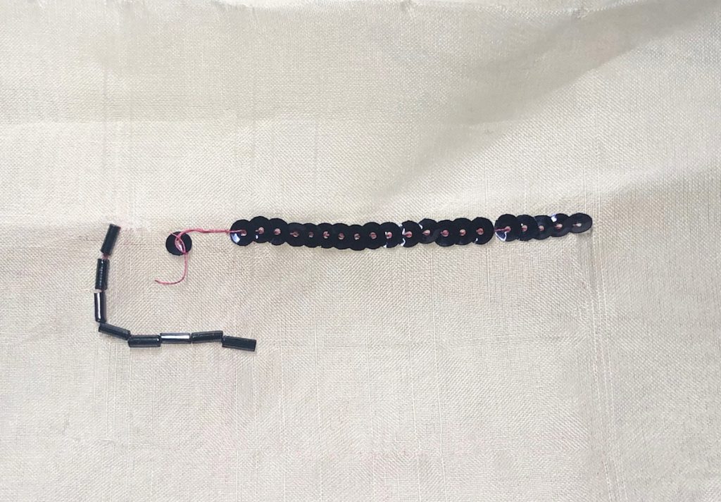 black curved sequins sewn onto gauze