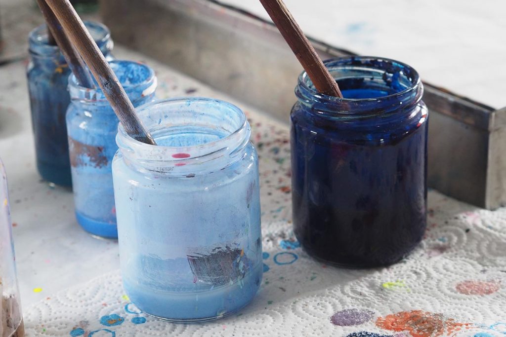 four glass jars blue paint